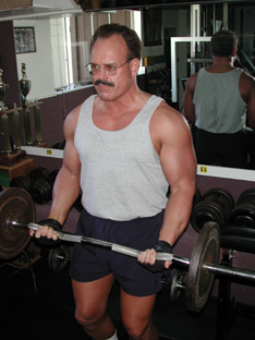 Persnal trainer Tim Dugas curls a barbell.